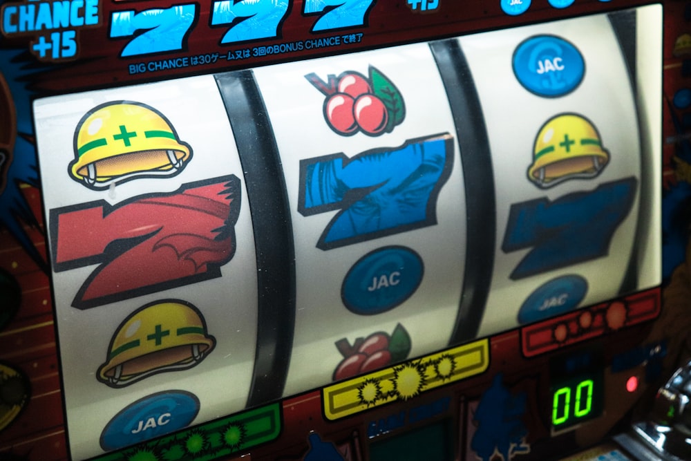 Layar mesin slot menampilkan simbol tujuh dan buah dengan lampu menyala